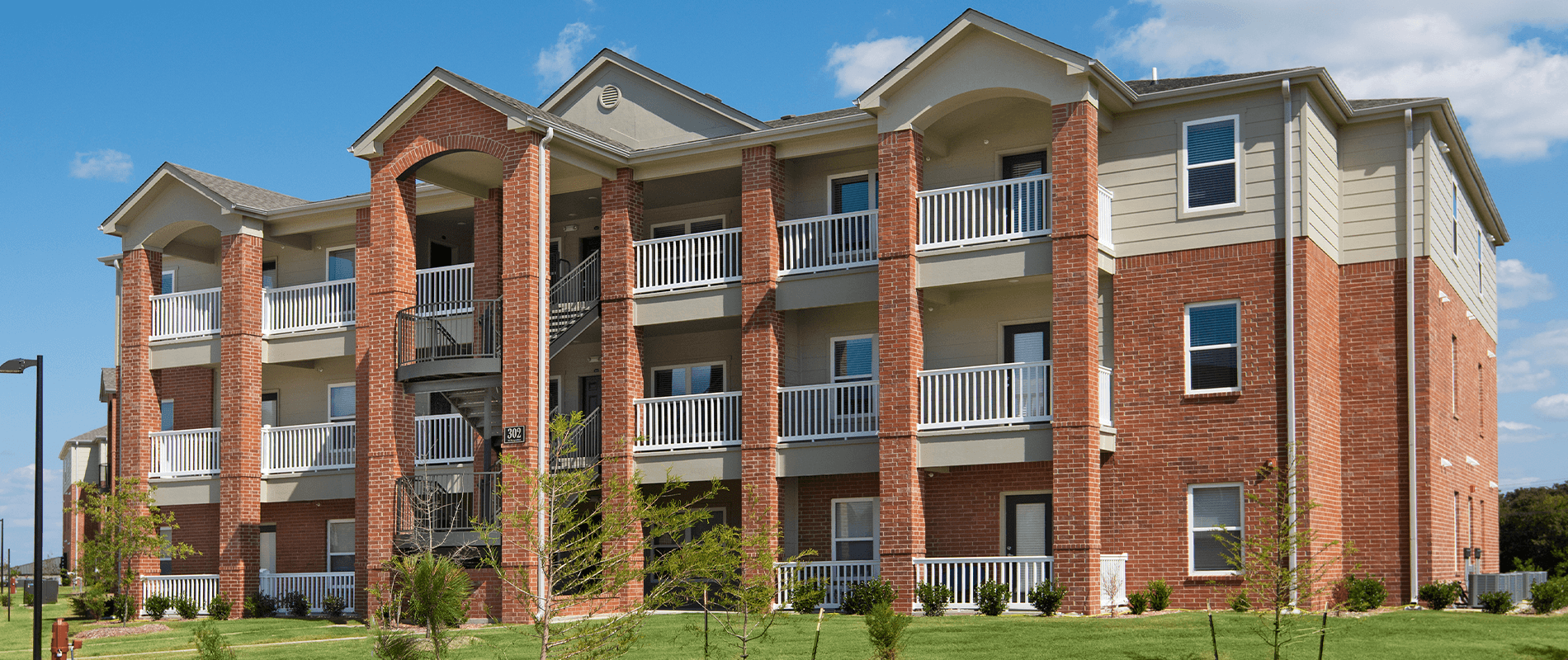 an exterior view of a brick apartment building with balconies